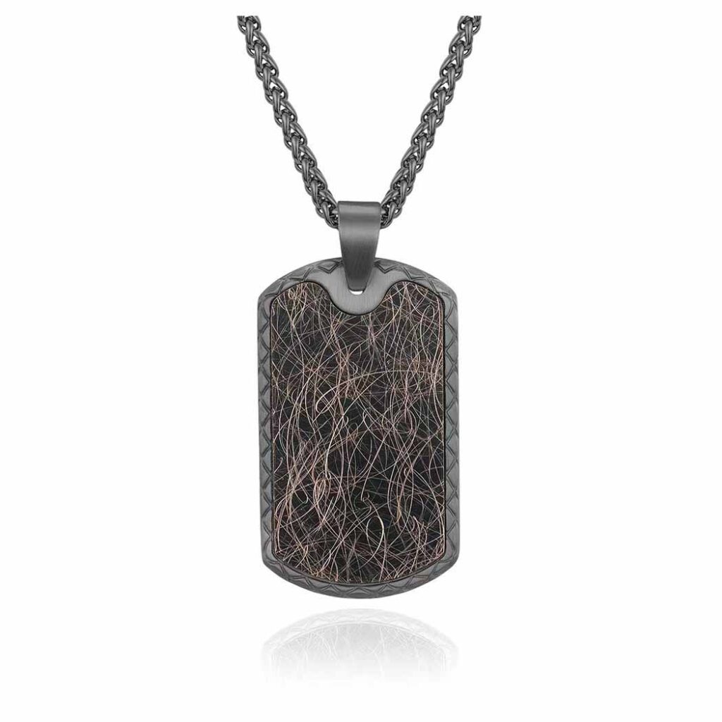 A modern pendant with a mesmerizing metallic mesh pattern of rose gold, silver, and bronze, bordered with etched details, suspended from a twisted dark chain against a white background.