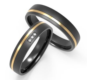 Black wedding ring with a trio of embedded diamonds and rose gold stripe