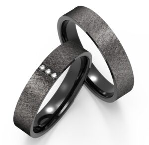 Satin finish gray and black band ring with embedded diamonds.