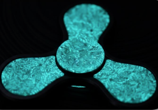 Luminescent forged carbon fiber block glowing in darkness